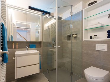Elegantes Badezimmer mit Glasdusche und modernen Elementen