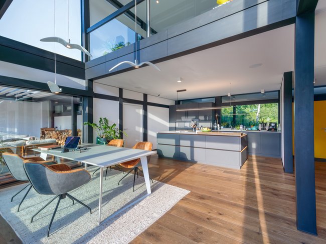 Modernes Designhaus mit Flachdach und offener Küche Helles, modernes Interieur mit Ess- und Wohnbereich im Designhaus