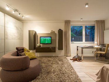 Modernes Wohnzimmer mit gemütlicher Einrichtung Helles Wohnzimmer mit modernem Mobiliar und Blick auf den Garten