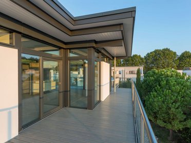Balkonansicht einer HUF Aufstockung mit modernen Fenstern und Holzterrasse