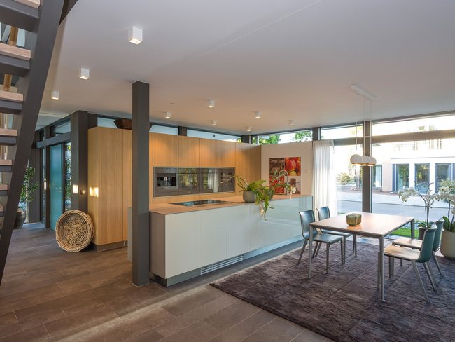 Moderne Küche mit Essbereich und großen Fenstern Küche mit Holz, Pflanzen und viel Tageslicht im modernen Design