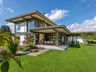 Helles modernes Fachwerkhaus mit großem Garten und blauen Himmel