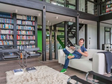Gemütliches Wohnzimmer in modernem Fachwerkhaus mit Bücherregalen