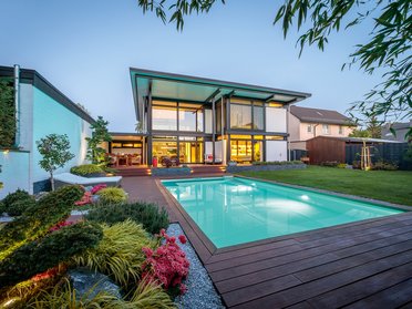 Modernes Flachdach-Designhaus mit Pool Stylisches Haus mit Glasfassade und schönem Garten