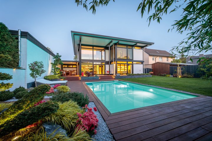 Modernes Flachdach-Designhaus mit Pool Stylisches Haus mit Glasfassade und schönem Garten