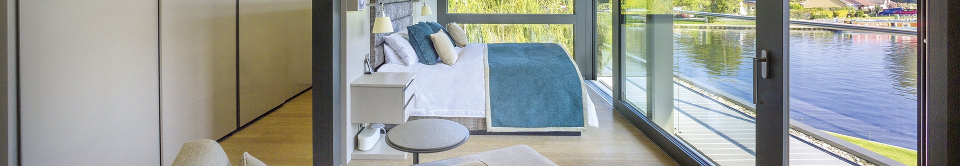Moderne Schlafzimmeransicht mit Blick auf den Wasserweg Elegantes Schlafzimmer mit großen Fenstern und Wasseraussicht