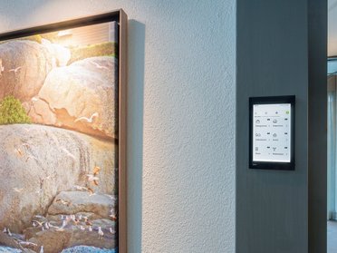 Modern interior with art and digital control panel A sleek wall featuring artwork and a digital touchscreen interface