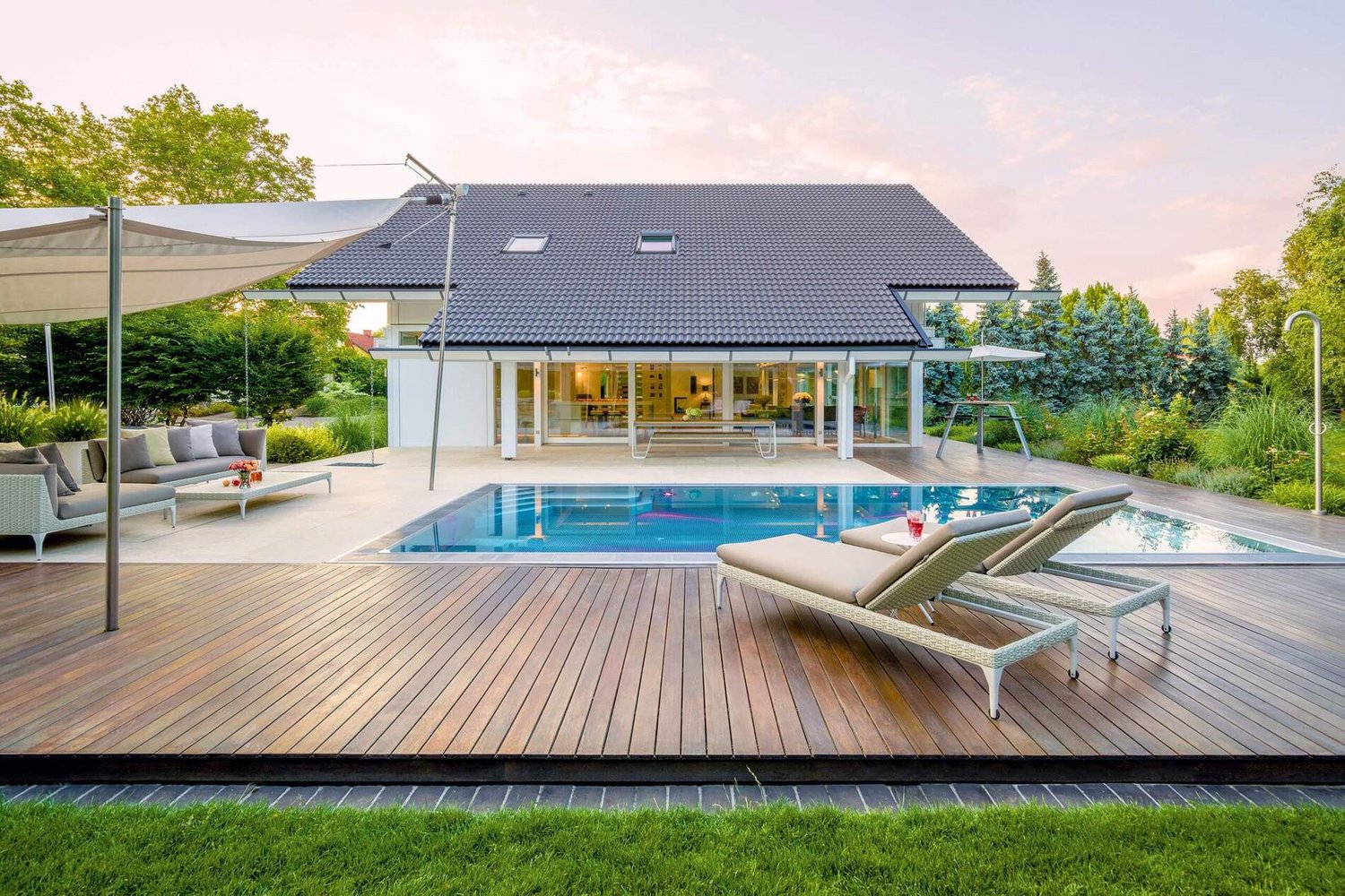 Weißes Fachwerkhaus mit Doppelpultdach, Pool und großzügiger Terrasse.