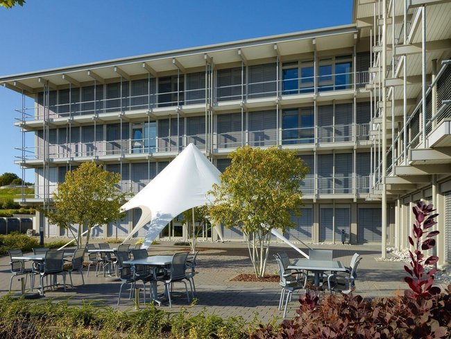Ansicht des Bürogebäudes HUF mit Pavillon und Garten