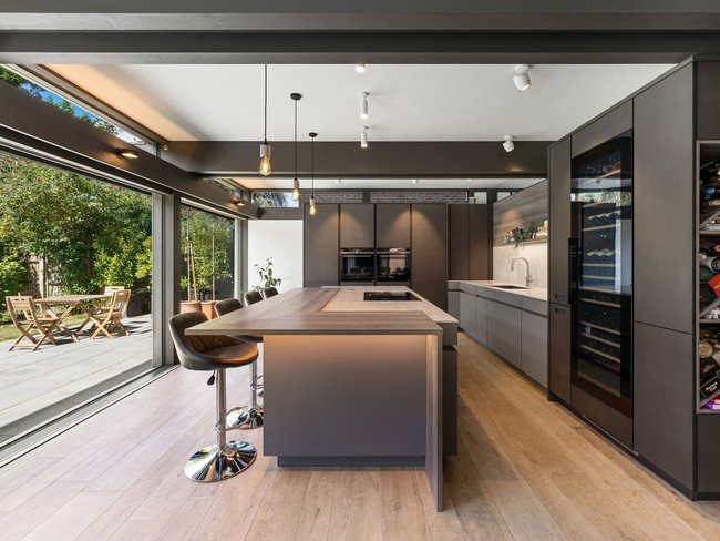 Elegante moderne Küche mit Kochinsel und Blick auf den Garten