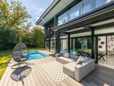 Lichtdurchflutetes Architektenhaus mit Pool Moderne Außenansicht eines architektonischen Hauses mit Garten und Pool