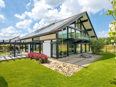 Helles Einfamilienhaus mit Glasfassade und gepflegtem Garten