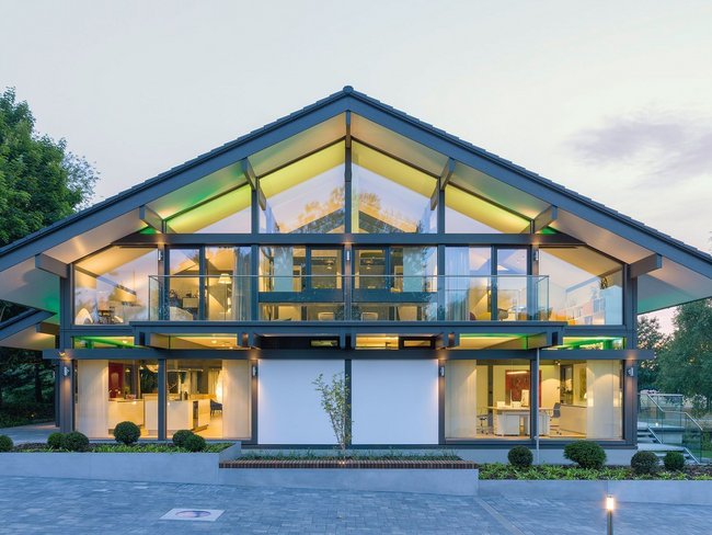 Helles modernes Gebäude mit großer Glasfront und Landschaftsgestaltung