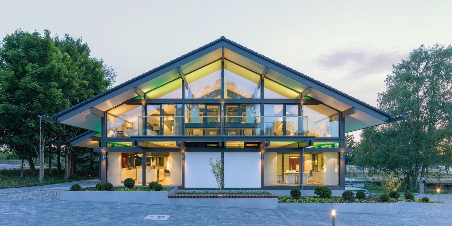 Helles modernes Gebäude mit großer Glasfront und Landschaftsgestaltung