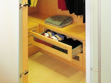 Moderne Kleiderschrank mit offenen Schubladen Einblick in einen Kleiderschrank mit gefalteter Kleidung und offenen Schubladen