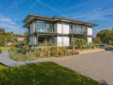 Moderne Architektur mit Garten und Parkplatz vor dem Haus