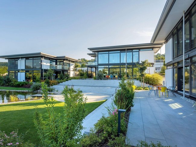 Moderne Architektur des HUF Bürogebäudes mit Teich und Garten