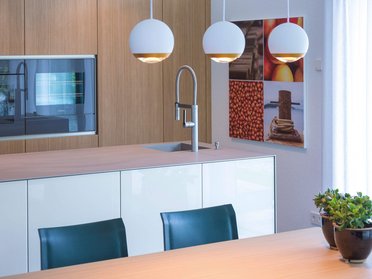 Moderne Küche mit Holz- und Glaselementen Helle Küchenumgebung mit Pflanzen und modernen Lampen