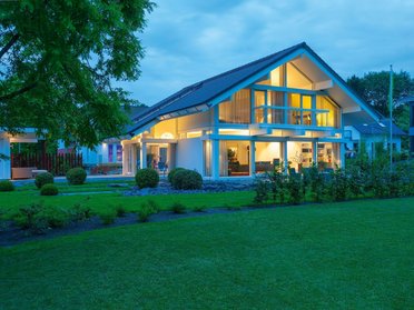 Architektur eines modernen Hauses mit grüner Landschaft und Dämmerungslicht