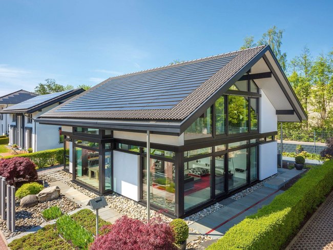 Moderne Architektur mit großen Fenstern und Solarzellen Ein stilvolles Haus mit Garten und modernen Designelementen