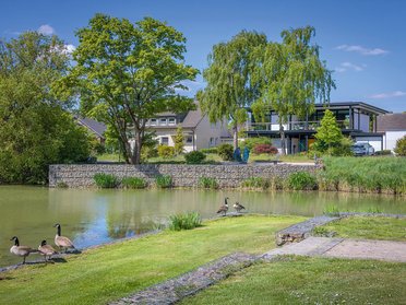 Modernes Designhaus mit Flachdach am Wasser Zeitgenössisches Designhaus in grüner Umgebung mit Wassersicht