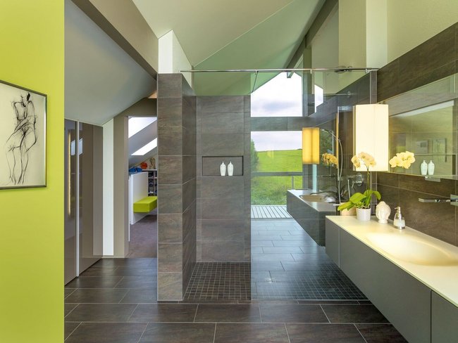 Geräumiges, elegantes Badezimmer mit grünen Akzenten und Blick auf die Landschaft