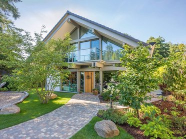 HUF Haus mit Anbau und Poolhaus Modernes HUF Haus mit Giebel, Poolhaus und Garagenanlage in grünem Umfeld