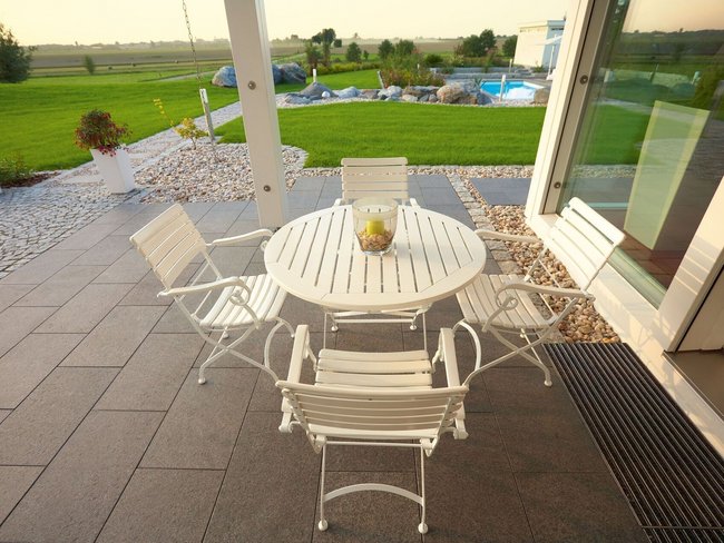 Fachwerkhaus HUF HAUS ART 4 mit Terrasse und Garten Moderne Terrasse mit Tisch und Stühlen, Blick auf Gartenlandschaft