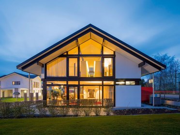 Architektur eines modernen Hauses mit warmem Licht und Garten
