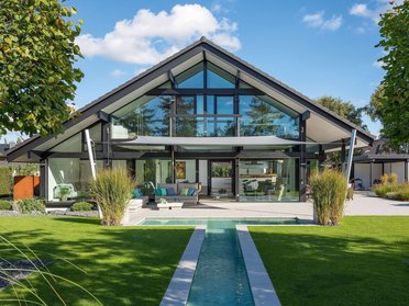 Transparentes Fachwerkhaus mit Garten und Bachlauf Modernes Holz- und Glashaus mit herrlichem Panorama und hochwertiger Qualität