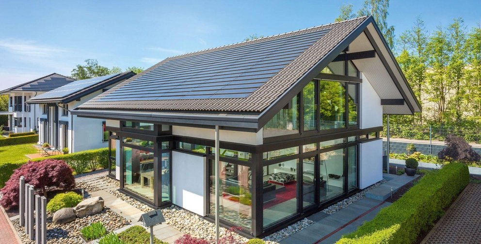 Helles, modernes Haus mit großen Fenstern und Solarzellen-Dach
