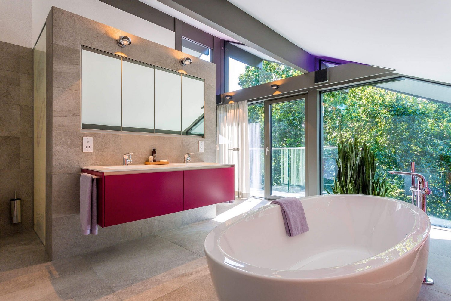 Helles Badezimmer mit Badewanne, Doppelwaschbecken und großen Fenstern