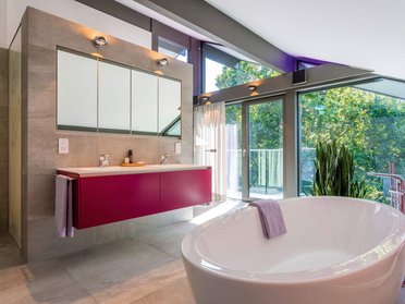 Helles Badezimmer mit Badewanne, Doppelwaschbecken und großen Fenstern
