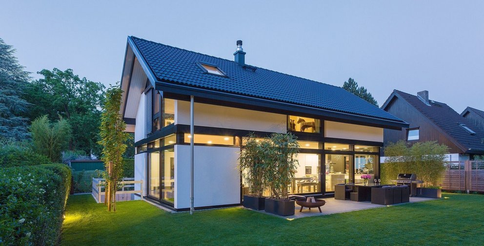 Stilvolles, modernes HUF Haus mit großen Fenstern und grünem Außenbereich