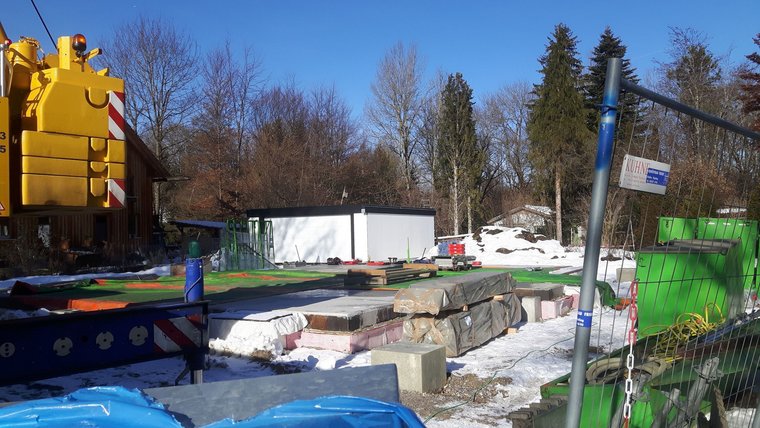 Baugelände in der Natur mit verschiedenen Materialien und einem blauen Himmel