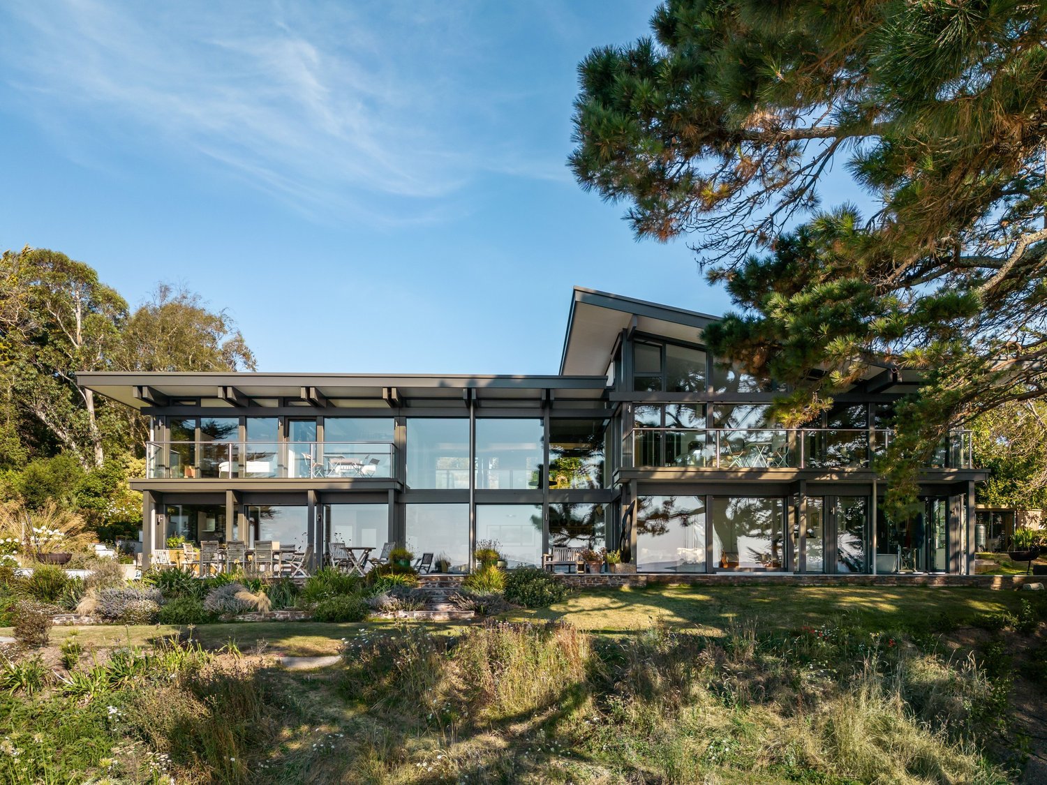 Moderne Architektur mit Glasfront und Gartenlandschaft