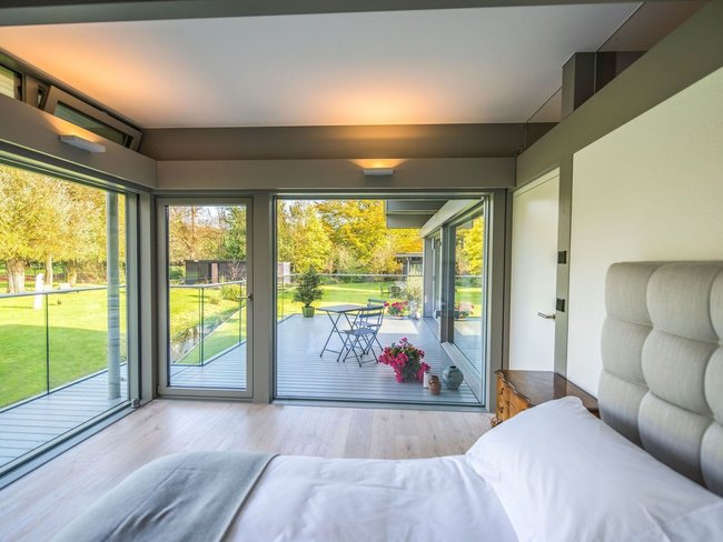 Stilvoller HUF Anbau mit großzügigem Wohnraum HUF Anbau erweitert Wohnraum mit großen Fenstern und Blick ins Freie