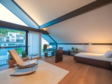 Helles und stilvolles Schlafzimmer mit großen Fenstern und Holzdetails