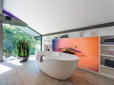 Helles Badezimmer mit freistehender Badewanne und dekorativen Pflanzen