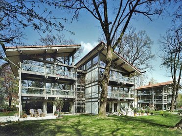 Generöse Architektur eines HUF HAUS Mehrfamilienhauses umgeben von Bäumen