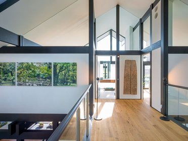 Helle Innenansicht eines modernen Hauses mit Kunstwerken und Holzfußboden