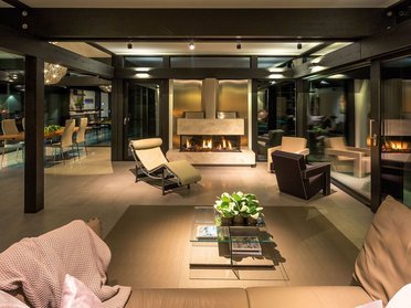 Moderne Innenansicht eines Fachwerkhauses mit Glas Lichtdurchflutetes Wohnzimmer mit hochwertiger Ausstattung und Kamin