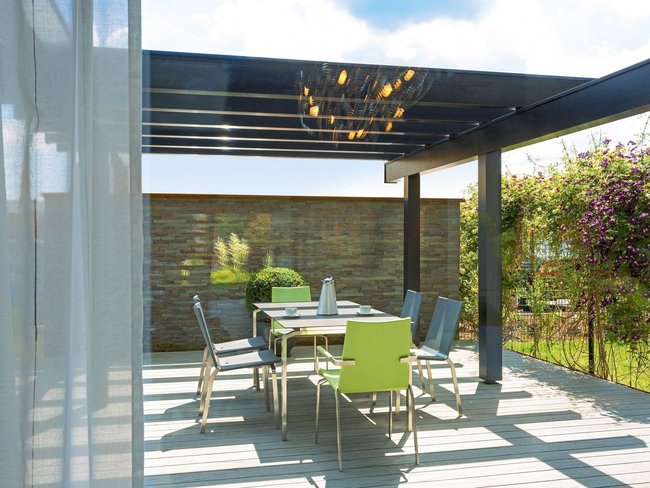 Gemütlicher Essbereich im Freien unter einer stilvollen Pergola