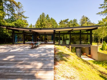 Moderner HUF Bungalow in natürlicher Umgebung Stylischer Bungalow mit großzügiger Terrasse und Panoramafenstern