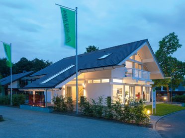 Ein hell erleuchtetes, modernes Haus bei Dämmerung