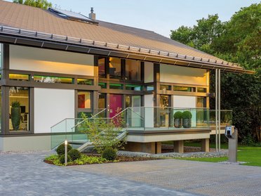 Elegantes Haus mit Glasfassade und gepflegtem Garten