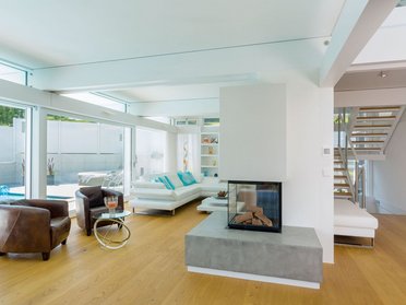 Helles Wohnzimmer mit großflächigen Fenstern und moderner Einrichtung