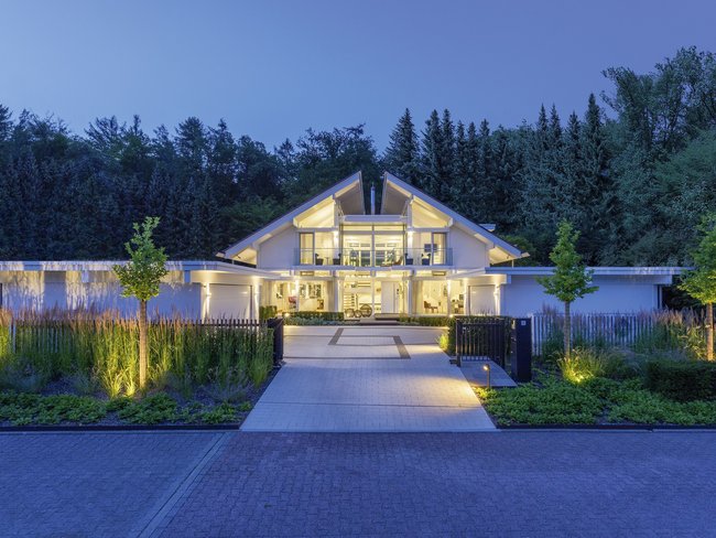 Fachwerk-Villa umgeben von Gartenlandschaft bei Dämmerung