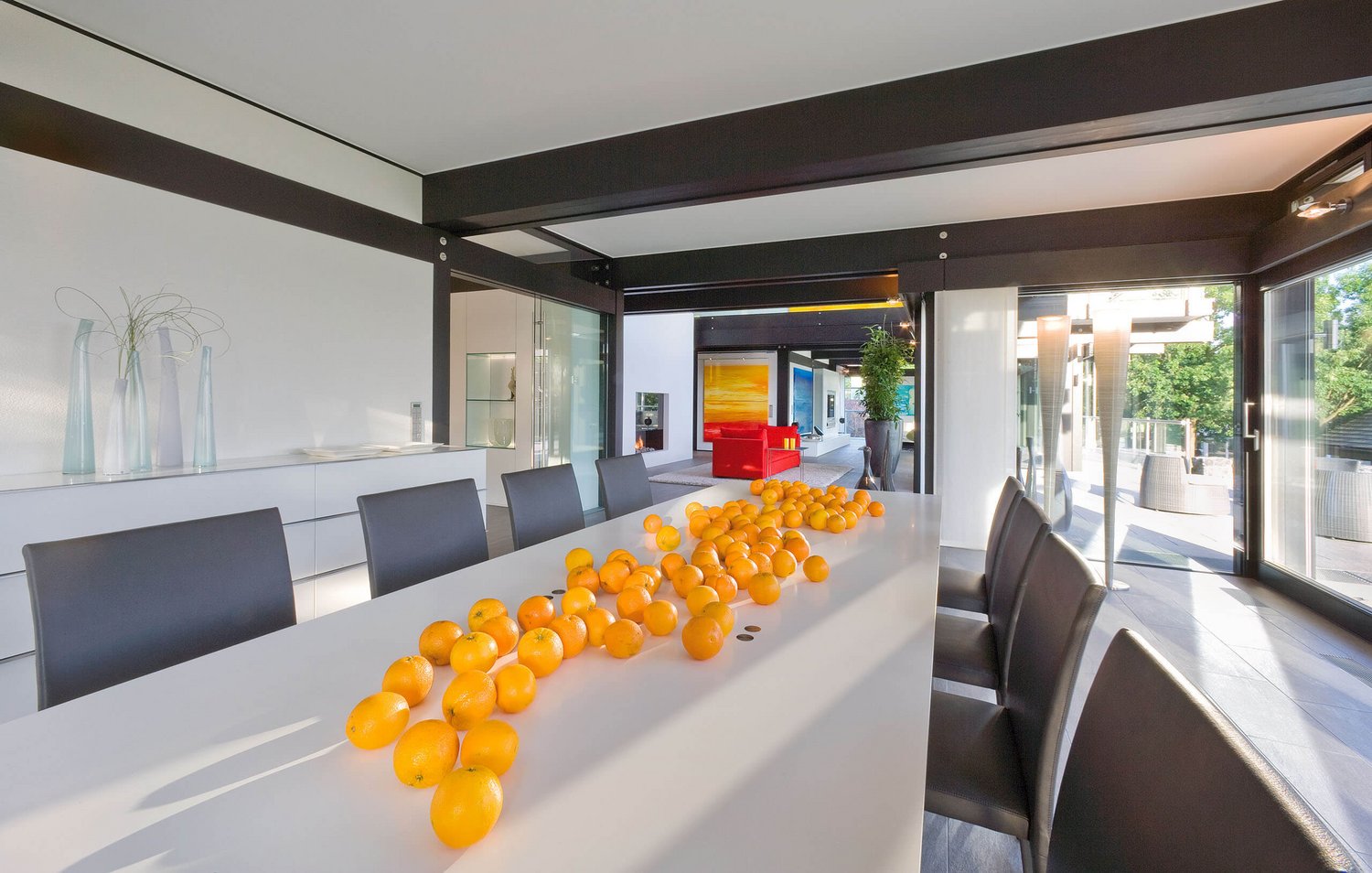 Elegantes Esszimmer mit einem langen Tisch und frischen Orangen