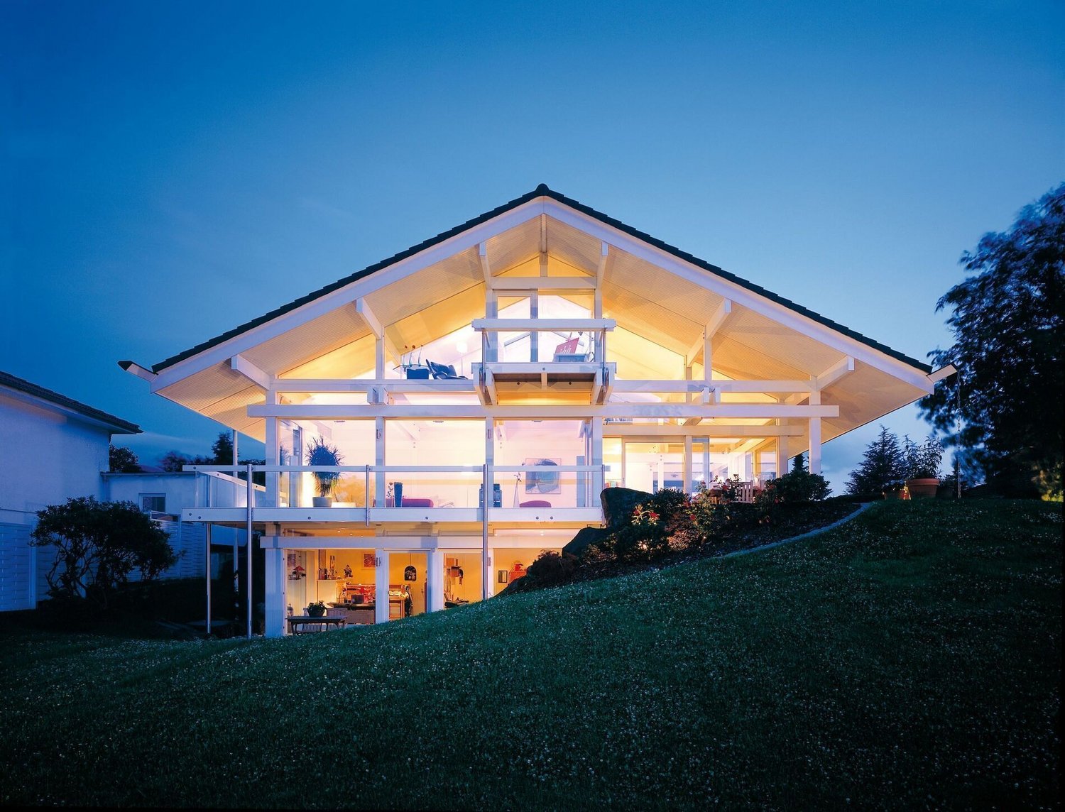 Ein HUF HAUS mit harmonischer Ästhetik und Lichtakzenten bei Nacht